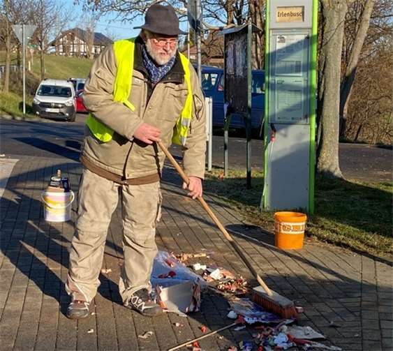 Mitinitiator der Müllaktion Kalle Kerstholt kehrt die Reste zusammen.