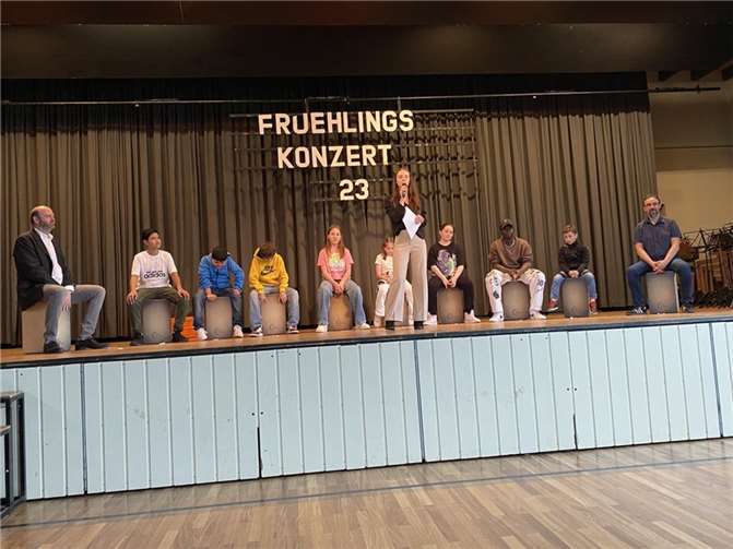 Moderatorin Nelly Moravec kündigt die dynamischen Rhythmen der Cajon AG unter Leitung von Musiklehrer Joachim Schmitz (li.) an. Quelle: Realschule plus und Fachoberschule Untermosel