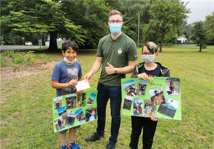 Moeen Tajik überreicht Phillip Born die Geldspende für 35 neue Bäume, Joshua Flatt zeigt eine Collage der eingereichten Bilder.Foto: privat