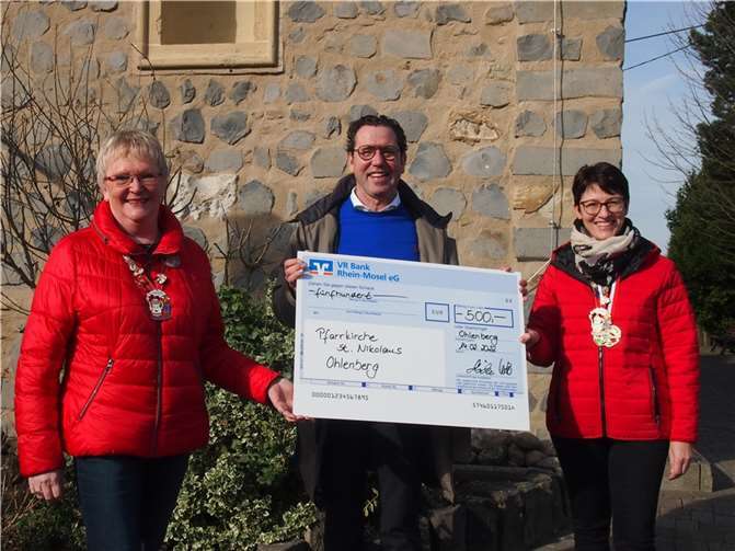 Möhnen überreichen vor der Ohlenberger Kirche den Scheck. Foto: Möhnenverein Mokkakännchen Ohlenberg