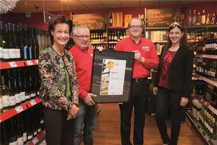 Monika Reule, Geschäftsführerin des Deutschen Weininstitutes freut sich gemeinsam mit Michael Glück, Thomas Fleischer und Weinprinzessin Kathrin Schnitzius (v.l.) über die Auszeichnung der Weinabteilung des Rewe-Marktes Glück.