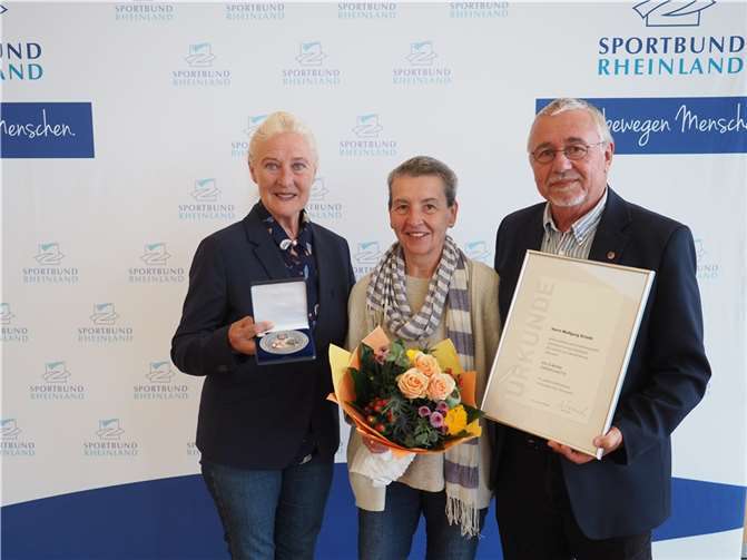 Monika Sauer (li.) ehrte Wolfgang Scheib (re.) für sein jahrzehntelanges Engagement mit der Ehrenplakette des Landessportbundes in Silber. Auch seiner Ehefrau Hanne wurde mit einem Blumenstrauß gedankt. Foto: Sportbund Rheinland