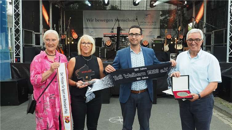Monika Sauer und Roger Lewentz überreichen die Vereinsauszeichnung an Repräsentanten. Foto: TuS Weibern