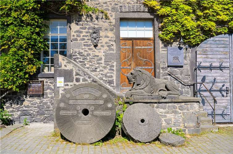 Mühlsteine am Eingang zu den Lavakellern in Mendig.  Foto: Mühlsteinrevier RheinEifel
