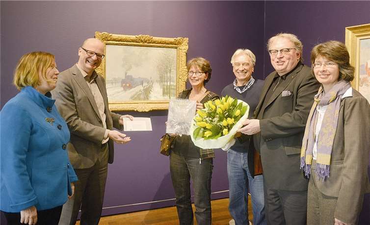 Museumsdirektor Oliver Kornhoff überreicht Blumenstrauß und Familienticket an Familie Vellrath.privat