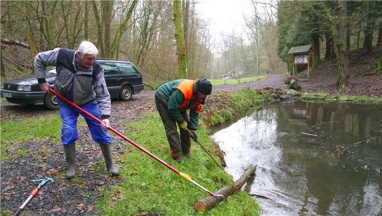 Mussten einen Baumstamm aus dem Mühlenweiher bergen: Werner Rockenfeller und Marc Schmitt bei der Beseitigung der Vandalismusschäden. Foto: Gerhard Neumann