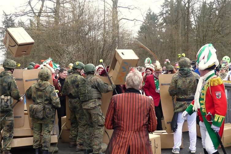 Nach Absperrband und Holzgittern ist auch die Kartonwand kein wirkliches Hindernis für die jecken Invasoren.