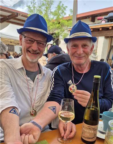 Nach dem Lauf zeigen Daniel Breslauer und Michael Rüb während des anschließenden Weinfestes stolz Medaille und Trollbach-Tattoo in die Kamera. 