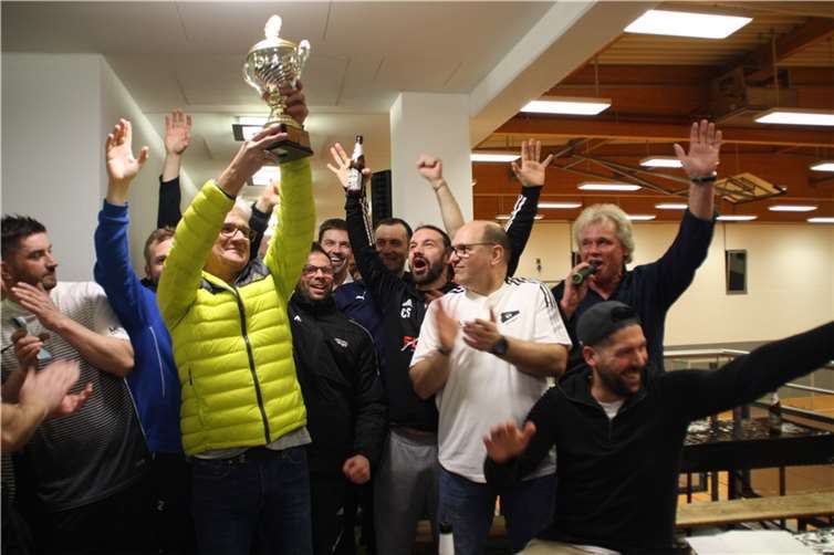 Nach der Überreichung des Makutec-Wanderpokals durch Turnierleiter Jürgen Huth und Ellingens AH-Sportdirektor Sascha Neitzert (1. und 2. v.re.) streckte Peter Nissing unter dem Jubel seiner Mitspieler der Alte Herren Urbach/Dernbach als Sieger des Hallenmasters 2023 den Pott in die Höhe. Foto: privat