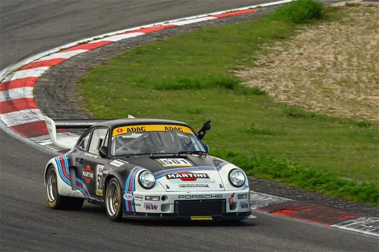 Nach seinem Gesamtsieg grüßt André Kunkel im Martini Porsche Carrera RSR aus dem Cockpit die Strecken-Marshalls auf seiner Auslaufrunde.
