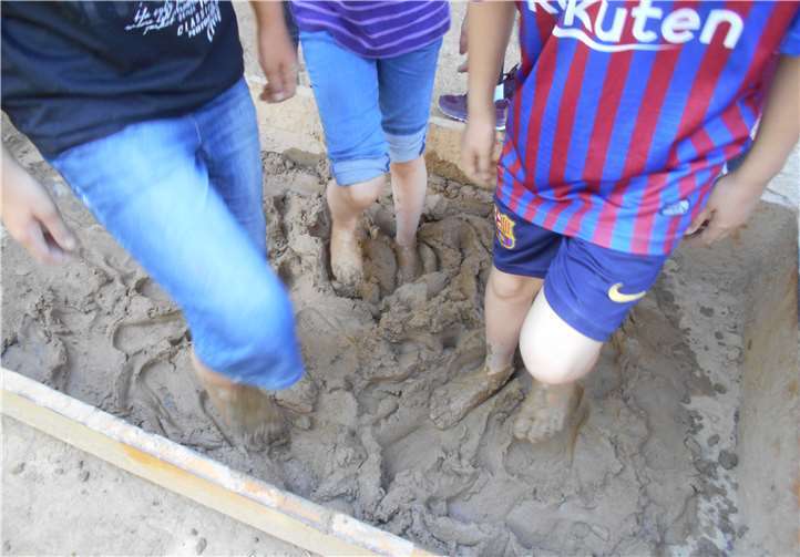 Nachdem der Lehm mit den Füßen vorbereitet wurde, erbauten 20 KGS-Schüler eine Fachwerkwand.