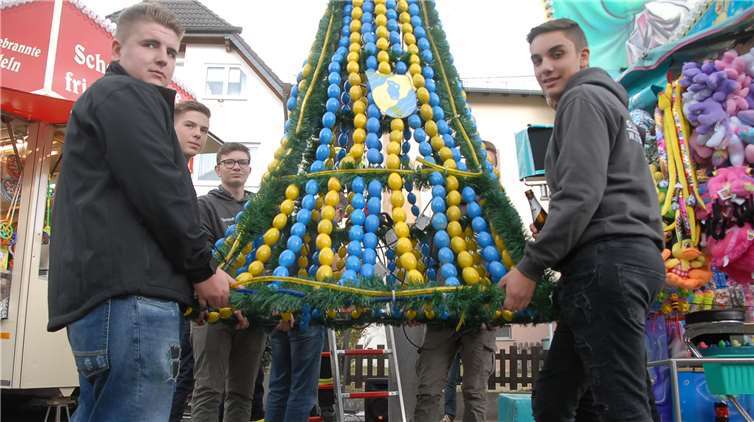 Nachdem die Eierkrone durch den Ort getragen wurde,hängen Mitglieder der Kirmesgesellschaft sie an demselbst gefällte und aufgestellten Kirmesbaum auf.