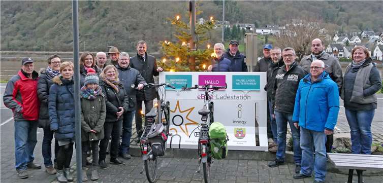 Nahmen gemeinsam die neue Ladestation für Elektrofahrräder an der Tourist-Information in Alken in Betrieb: Michael Dötsch von innogy, Verbandsbürgermeister Bruno Seibeld und Ortsbürgermeister Walter Escher mit Vertretern des Gemeinderates und Mitgliedern des Fremdenverkehrsvereins Alken. innogy