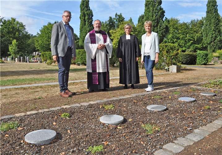 Nehmen das neue Baumgrab mit seinen runden Granitplatten in Augenschein (v.l.): der Erste Beigeordnete Hans Dieter Wirtz, Pfarrer Franz-Josef Steffl, Pfarrerin Ingeborg Dahl und Ursula Schmitz, Leiterin des städtischen Fachbereichs Bürgerbüro, Personenstandswesen, Statistik und Wahlen. Quelle: Stadt Meckenheim