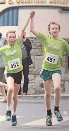 Nele (W12) und Michael (M13) laufen als Sieger gemeinsam über die Ziellinie.privat