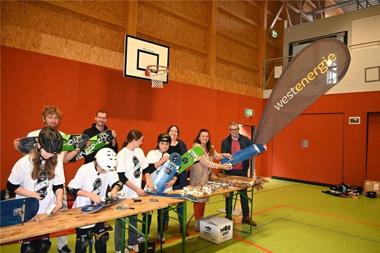 Neu in diesem Jahr beim Skater-Workshop: Die Kinder und Jugendlichen lernen selbst am Board zu schrauben (im Hintergrund v.l. Konstantin Schatz – skate-aid, David Weyel – RheinFlanke, Annica Starke-Mutschler – Jugendhilfeplanerin, Lydia Bauer – Kommunalbetreuerin des Kommunalen Partnermanagements bei Westenergie und Hans Dieter Wirtz – Erster Beigeordneter).Foto: Stadt Meckenheim