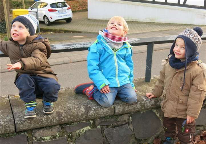 Neugierig verfolgen die Kinder das Anbringen der Baumspitze.