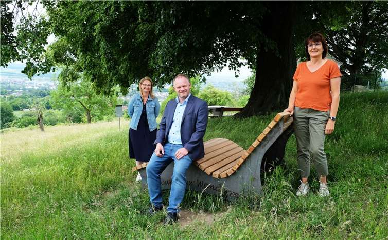 Neuwieds Oberbürgermeister Jan Einig (Mitte), Naturpark-Geschäftsführerin Irmgard Schröer (re.) und Julia Kloos-Wieland vom Amt für Stadtmarketing blicken von der Relaxliege am Lindenbäumchen ins Neuwieder Becken. Quelle: Stadt Neuwied