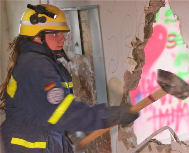 Nicht nur Männer können den Hammer schwingen. Eine THW-Helferin vergrößert den Durchgang.