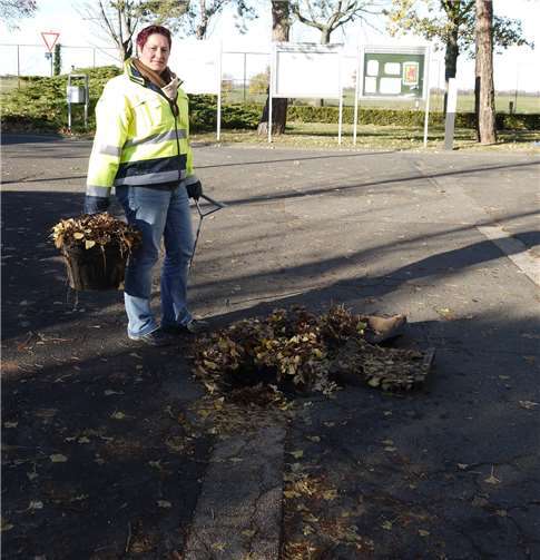 Nicole Danziger von der Gemeinde Swisttal zeigt, wie viel Laub sich im Straßenablauf gesammelt hat.privat