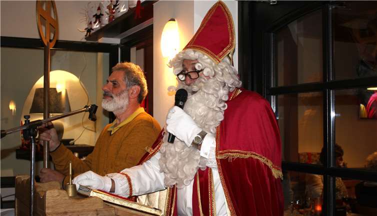 Nikolaus, Udo Groß, las aus seinem goldenen Buch vor. Neben ihm steht Carlos, der ihm solange den Bischofsstab hält.