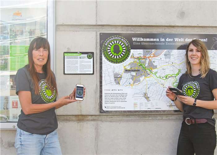 Noch schnell das „Unterwegspaket“ auf das Samertphone laden – und schon kann die Tour auf dem Wanderweg „Montabäurer Mären“ losgehen. Wie einfach das geht testeten die beiden Initiatorinnen Karin Maas (l.) und Carolin Nebgen am Startpunkt ICE-Bahnhof Montabaur. Foto: VG Montabaur
