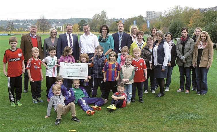 Nur lachende Kindergesichter gab es im Stadion des SV Niederwerth, als LOST Harald Kruse mit seiner Frau (hinten links) einen dicken Scheck mitbrachten. Chef-Organisator Dieter Dierkes (links außen) und Markus Stein, SV Niederwerth (rechts daneben), freut es genauso wie Madeleine Vogel und Ute Steinebach, Leiterinnen von Grundschule und Kindergarten (halb rechts Mitte).Privat