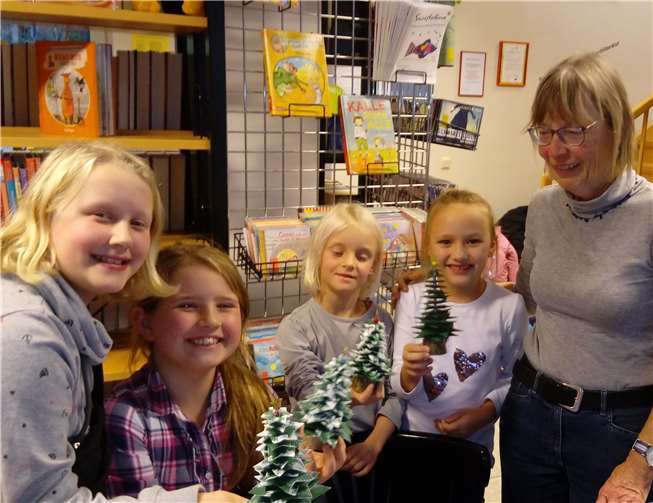 „O Tannenbaum“ - Leonie, Lea, Mira und Amalia (von links) präsentieren Bücherei-Mitarbeiterin Mechthilde Habeth ihre Bäumchen. Foto: privat