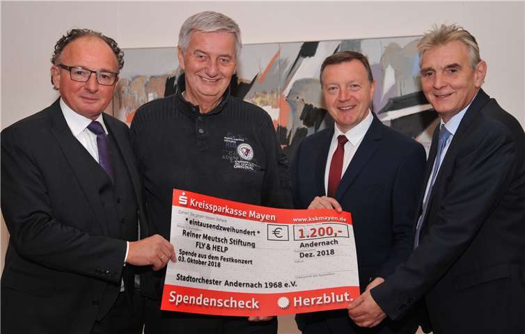 Oberbürgermeister Achim Hütten (links), Bürgermeister Claus Peitz (rechts) und der Musikdirektor des Stadtorchesters, Bertram Kleis (2. von rechts), überreichten die Spendengelder des Festkonzerts zum Tag der Deutschen Einheit an Reiner Meutsch, dessen Stiftung „Fly & Help“ die „Andernach-Schule“ auch mit Hilfe dieser Spende in Ruanda bauen kann. Stadt Andernach/Maurer