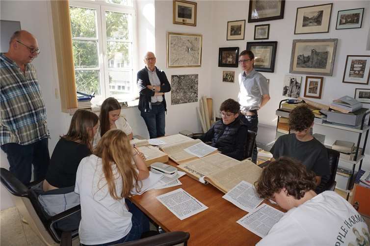 Oberbürgermeister Dirk Meid beobachtet gemeinsam mit Lehrer Edwin Kleis und Archivar Stefan Wilden die Schülerinnen und Schüler bei der Quellenarbeit.