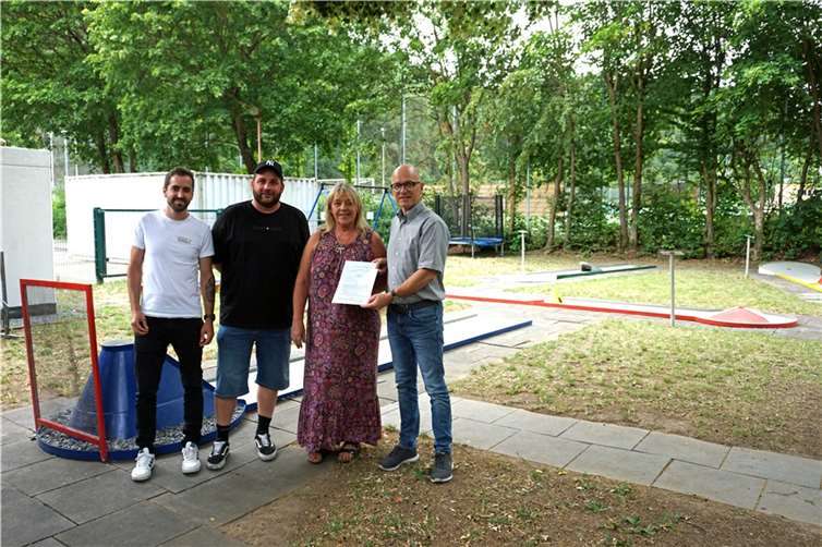 Oberbürgermeister Dirk Meid überreicht Pia Dietz den Pachtvertrag über die Minigolfanlage.  Foto: Jaqueline Blang/ Stadt Mayen