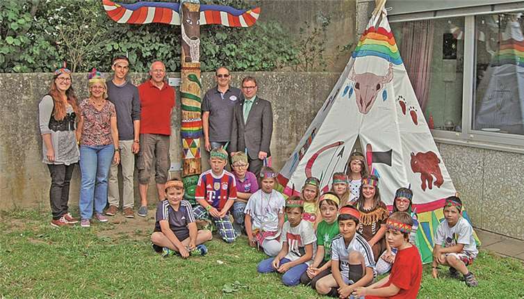 „Regenbogenbüffel“ präsentieren ihr Indianer-Projekt Oberbürgermeister Wolfgang Treis, Hausmeister Gerd Gräfen, Schuleiter Christoph Buschmann, Fabian Mayer, die Leiterin des Ganztagsbereich Silivia Frank und Hanna Steffens (v.r.n.l.) mit den Grundschülern der „Indianer-AG“. Jacqueline Blang