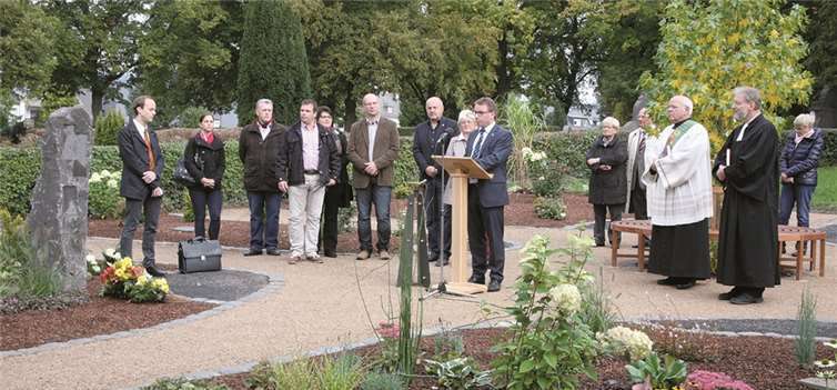Inmitten von Blumen und Pflanzen die letzte Ruhe finden Oberbürgermeister Wolfgang Treis (am Pult) bei der Eröffnungs- und Segnungszeremonie in der gelungenen Kulisse des Mayener Memoriam-Gartens. WE