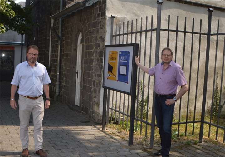 Oberbürgermeister Wolfgang Treis und der stellvertretende Vorsitzende Dr. Lutz Grunwald vor dem neu installierten Schaukasten der Burgfestspiele am Alten Arresthaus. Foto: Jaqueline Blang/Stadt Mayen