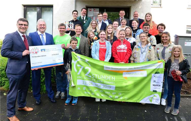 Oliver Engels, Direktor des Regionalmarktes MayenRhein der Volksbank RheinAhrEifel, und Bruno Jaeger, Geschäftsführer der Bürgerstiftung der Bank (v.l.), übergeben eine Spende in Höhe von 4.250 Euro an einen Teil der Jugendlichen, die an der „72-Stunden-Aktion“ des Bundes der Deutschen katholischen Jugend teilnehmen. Foto: Udo Stanzlawski