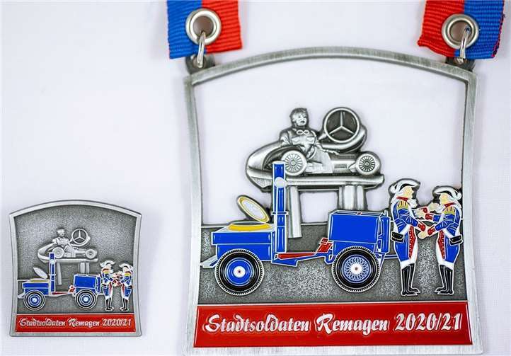 Orden und Ansteckpin zeigen die Goulasch-Kanone vor dem Caracciola-Denkmal. Foto: privat