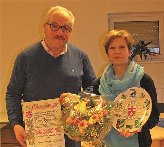 Ortsbürgermeister Andreas Perscheid überreichte Beate Koppenhöfer eine Urkunde, den Wappenteller sowie einen Blumenstrauß. privat