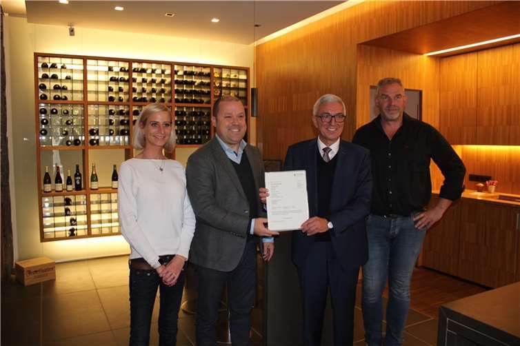 Ortsbürgermeister Benjamin Vrijdaghs (2.v.l.) und Innenminister Roger Lewentz (3.v.l.) bei der Übergabe des Förderbescheids im Rotweingut Jean Stodden.  Foto: MdI RLP