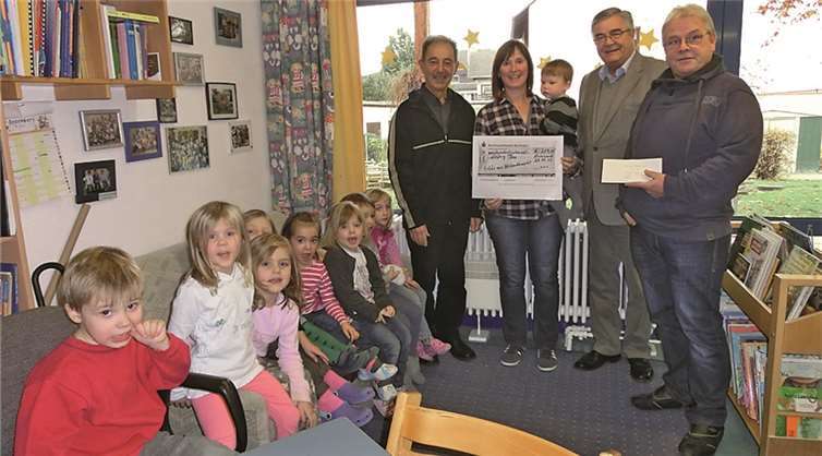 Ortsbürgermeister Herr Gans, erster Vorsitzender Peter Strohof und Michael Loch überreichten der Kindergartenleitung den großzügigen Scheck. privat