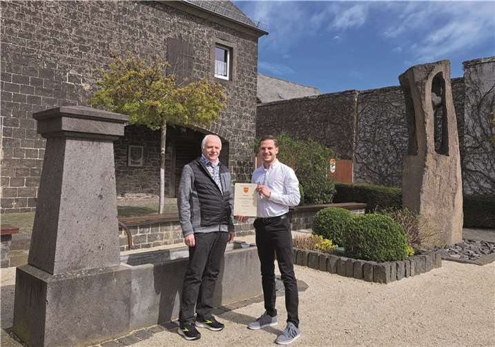 Ortsbürgermeister Lukas Ellerich –rechts- überreicht Fritz Peter Hanke die Urkunde für den Großen Wappenteller der Gemeinde Thür.  Foto: FRE