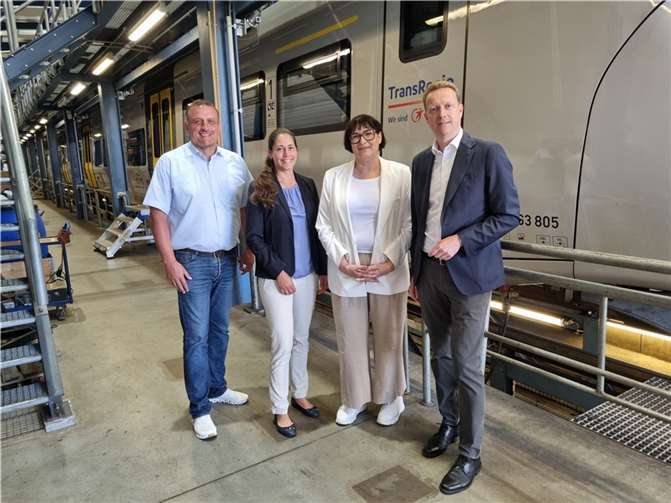 Ortsbürgermeister Peter Wilkes, Annelie Harre, Anette Moesta MdL und Henrik Behrens, Geschäftsführung TransRegio, vor einem Regionalzug.  Foto: Sebastian Kirchner