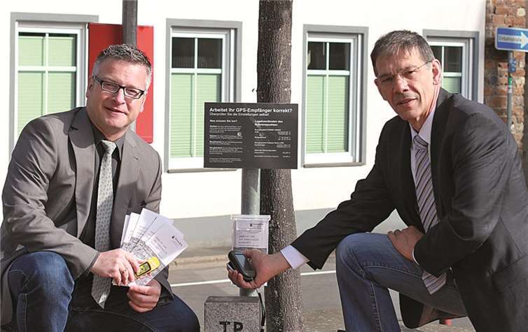 Ortsbürgermeister Philipp Thönnes (links) und der Leiter des Vermessungs-und Katasteramts Mayen, Klaus Marder, am neuen GPS-Vergleichspunkt auf dem Treiser Marktplatz. privat