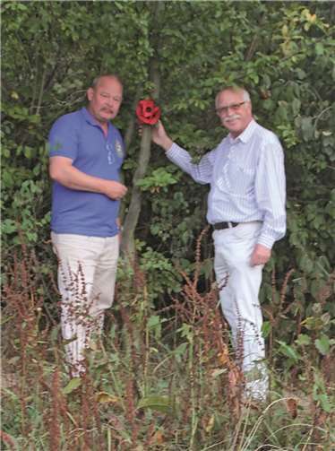 Ortsbürgermeister Richard Keuler und Dominic Howard von der britischen Veteranenvereinigung des 49th Squadron der Royal Airforce befestigten an der Absturzstelle eines Lancester Bombers die Papiermohnblume. privat