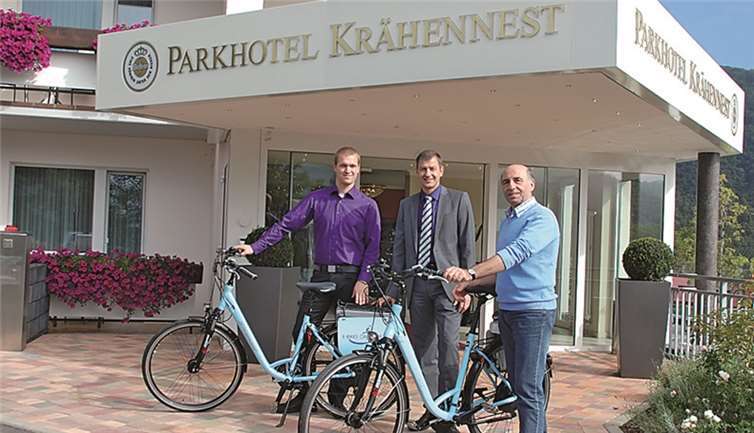 Ortsbürgermeister Rudolf Zenz und Björn Dehren, Juniorchef des Parkhotels Krähennest, freuten sich über zwei E-Bikes, die der Leiter der Region Rauschermühle bei RWE, Michael Dötsch (mitte) der Ortsgemeinde überreichte. privat