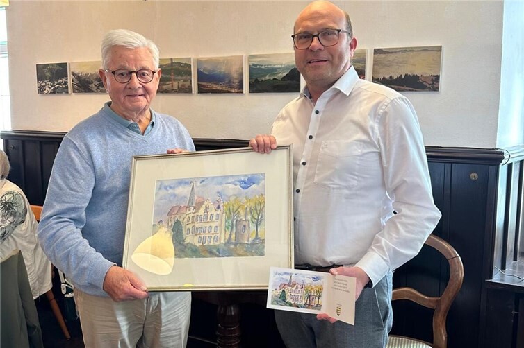 Ortsbürgermeister Stefan Betzing stellte zusammen mit dem Maler der Burg Dattenberg, Hans-Joachim Schmitz, die neue Glückwunschkarte der Ortsgemeinde Dattenberg den Besuchern der fairen Kaffeetafel vor.