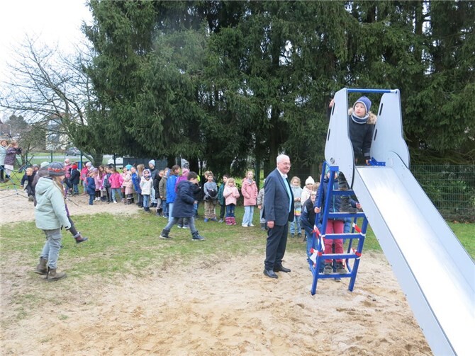 Ortsbürgermeister Willi Knopp beaufsichtigt das Rutschen der Kinder