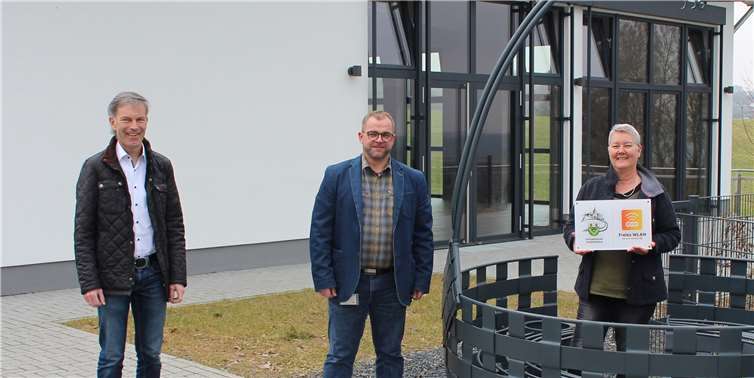 Ortsbürgermeisterin Carolin Bruns, Volker Weiand und evm-Kommunalbetreuer Norbert Rausch trafen sich am „Treffjen“ zur Übergabe der Hinweistafel zum freien WLAN evm-connect. Foto: evm