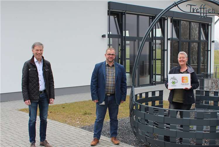 Ortsbürgermeisterin Carolin Bruns, Volker Weiand und evm-Kommunalbetreuer Norbert Rausch (links) trafen sich am „Treffjen“ zur Übergabe der Hinweistafel zum freien WLAN evm-connect. Foto evm