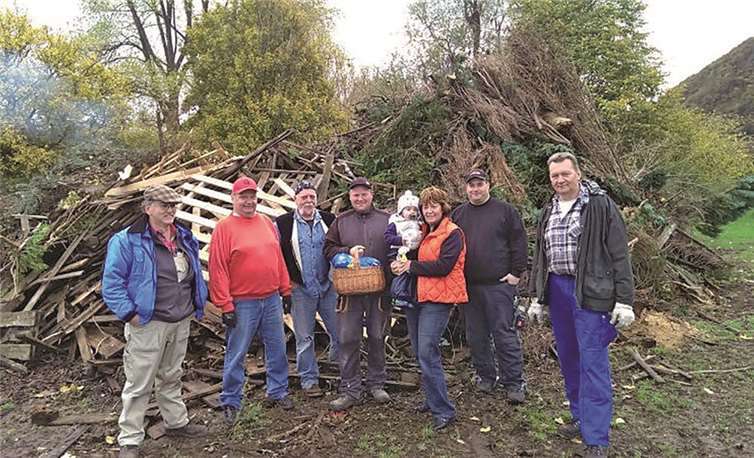 Ortsbürgermeisterin Christel Ripoll (3.v.r.) gemeinsam mit den freiwilligen Helfern vor dem Brohler Martinsfeuer. privat