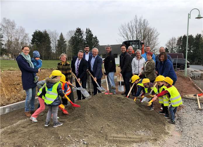 Ortsbürgermeisterin Roswitha Schulte (3.v.l.), Bürgermeister Hans-Werner Breithausen (4.v.l.), Landrat Achim Hallerbach (6.v.l.), Ratsmitglieder, Planer und Bauunternehmer nahmen gemeinsam mit den Kita-Kindern zum Baustart den Spaten in die Hand.